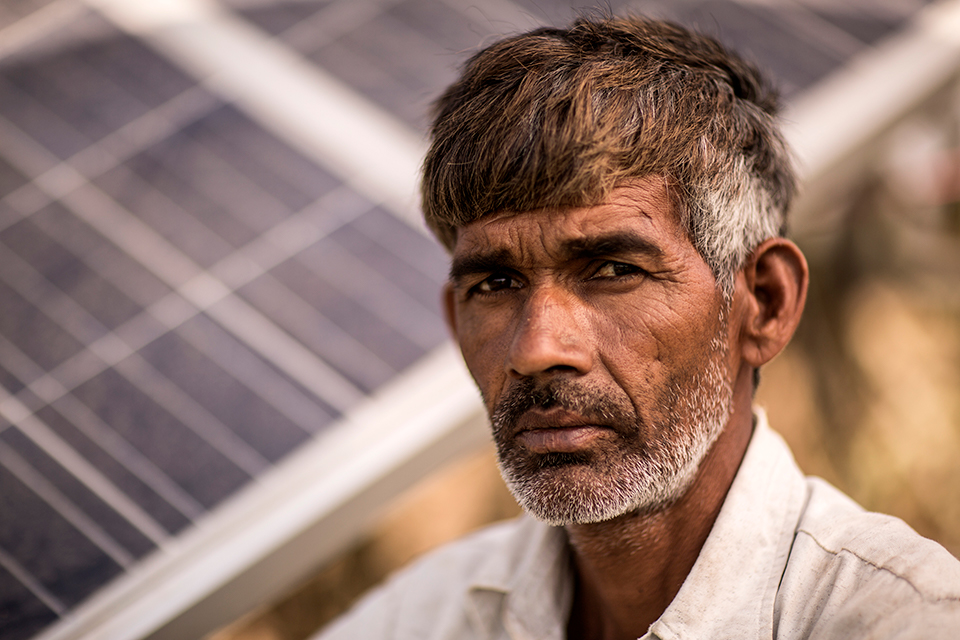 Madholal Aheer, in front of his solar panels, which he uses to power his irrigation system. Madholal, like many JIVA farmers, uses pumps to draw water from hand-cut wells that are over 60 feet deep.